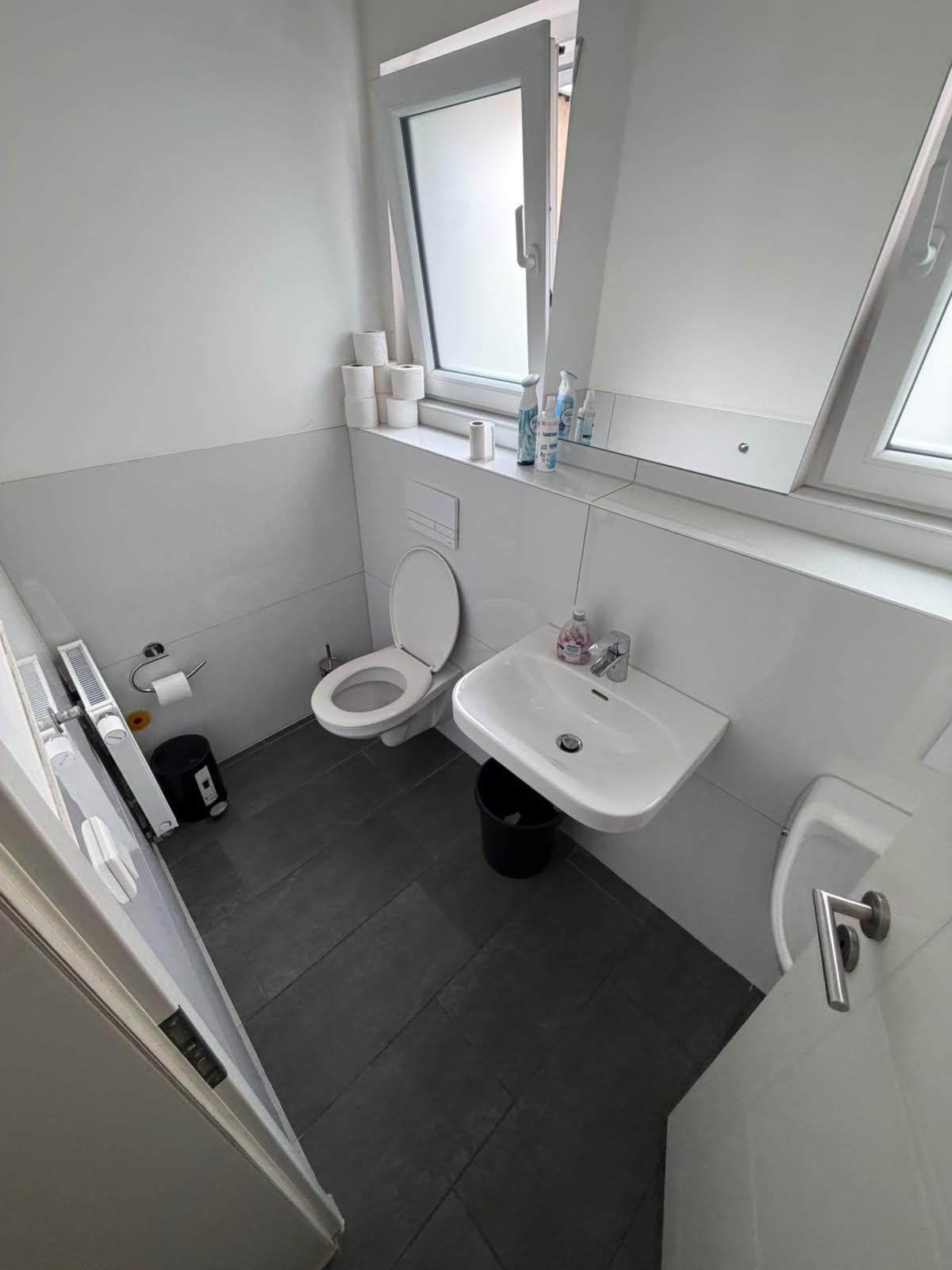 Gereinigter Büro-Waschraum mit WC, Waschbecken und aufgefülltem Toilettenpapier, Düsseldorf-Oberbilk