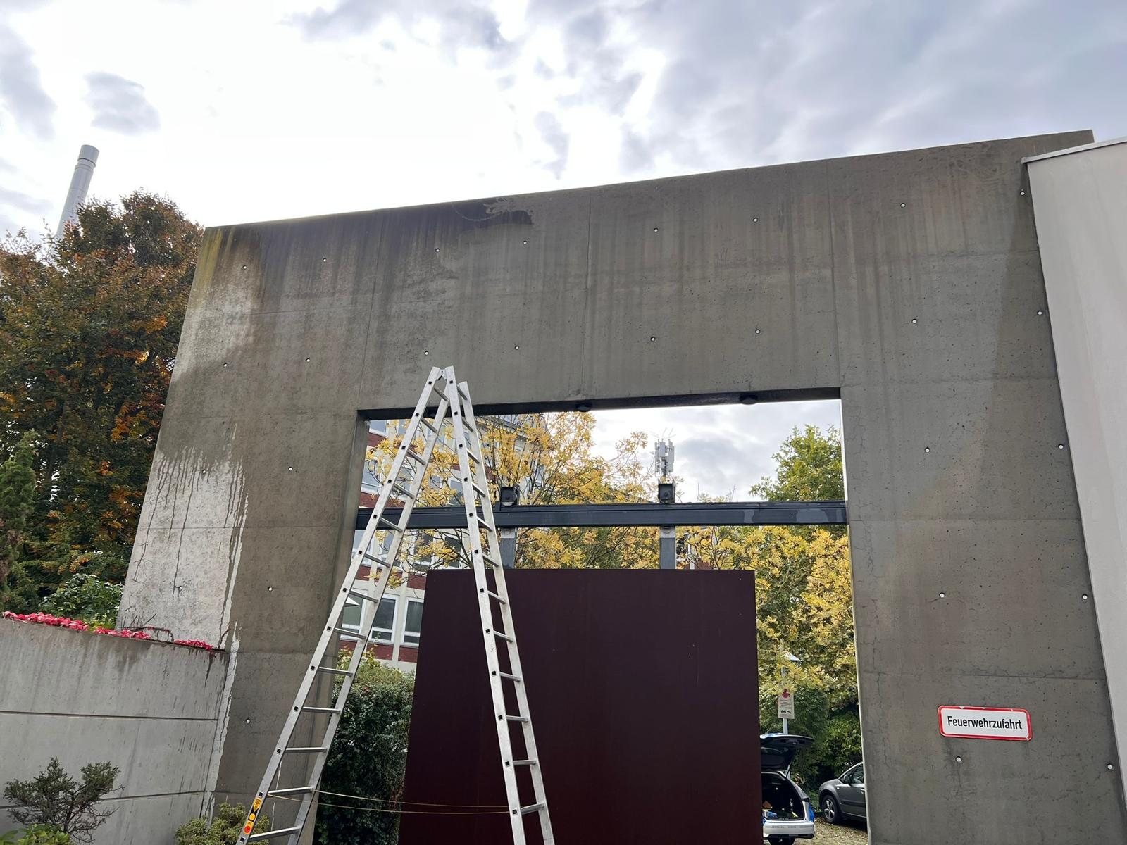 Sichtbeton-Portal an einer Feuerwehrzufahrt mit Leiter während der Hochdruckreinigung, Düsseldorf-Oberbilk