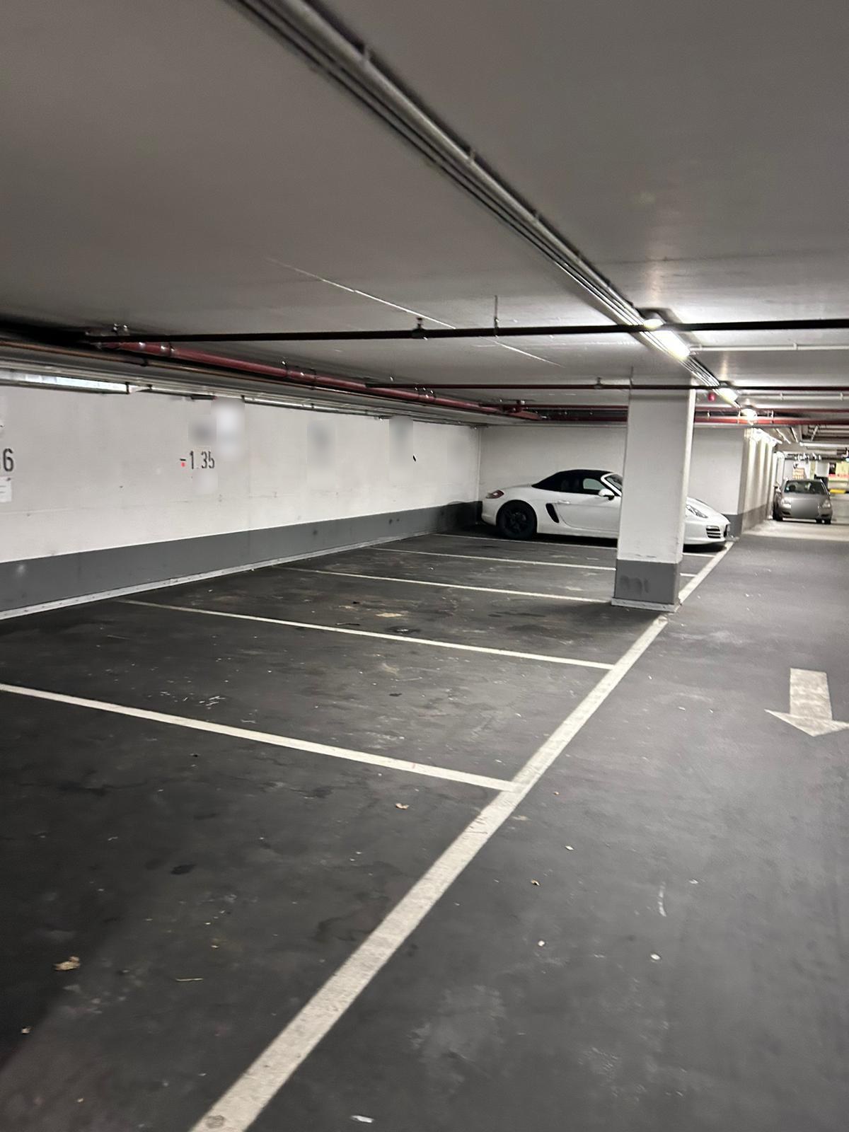 Stellplätze in einer Tiefgarage vor der Reinigung mit Staub und Schmutzablagerungen auf dem Boden